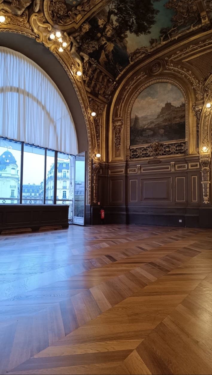 Parquet en point de Hongrie poncé et vitrifié dans un salon historique à décor doré, vue sur les toits de Paris