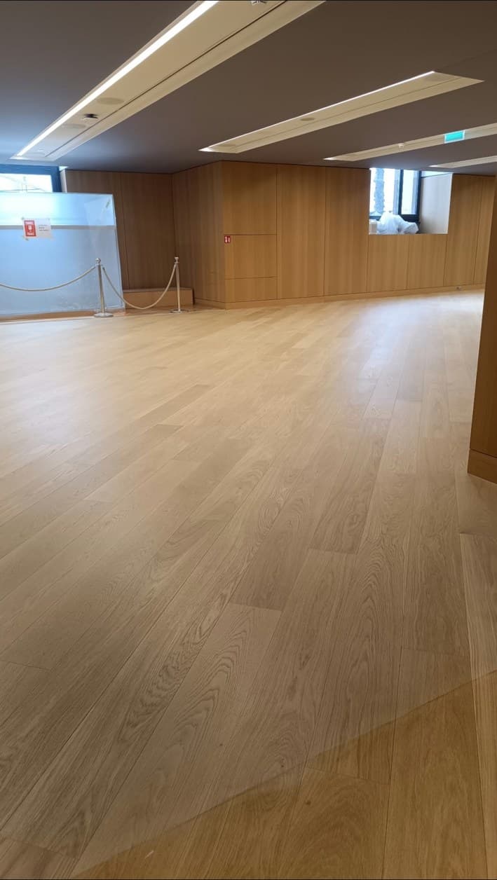 Grand parquet en chêne à lames larges poncé et vitrifié dans un espace d’exposition